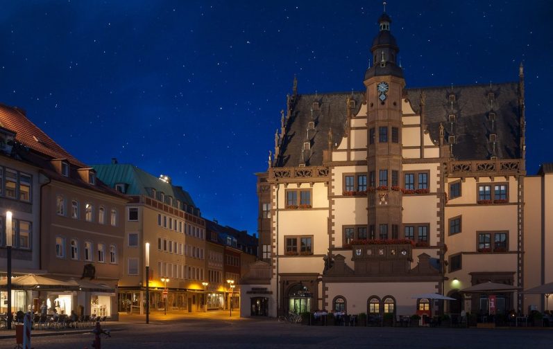 Historisches Rathaus in Schweinfurt am Abend in einem städtischen Platz, beleuchtet von Straßenlaternen.